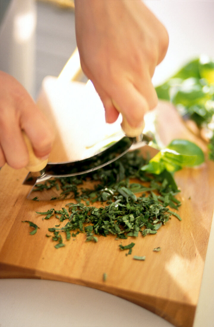 Fresh basil chopped on wooden cutting board