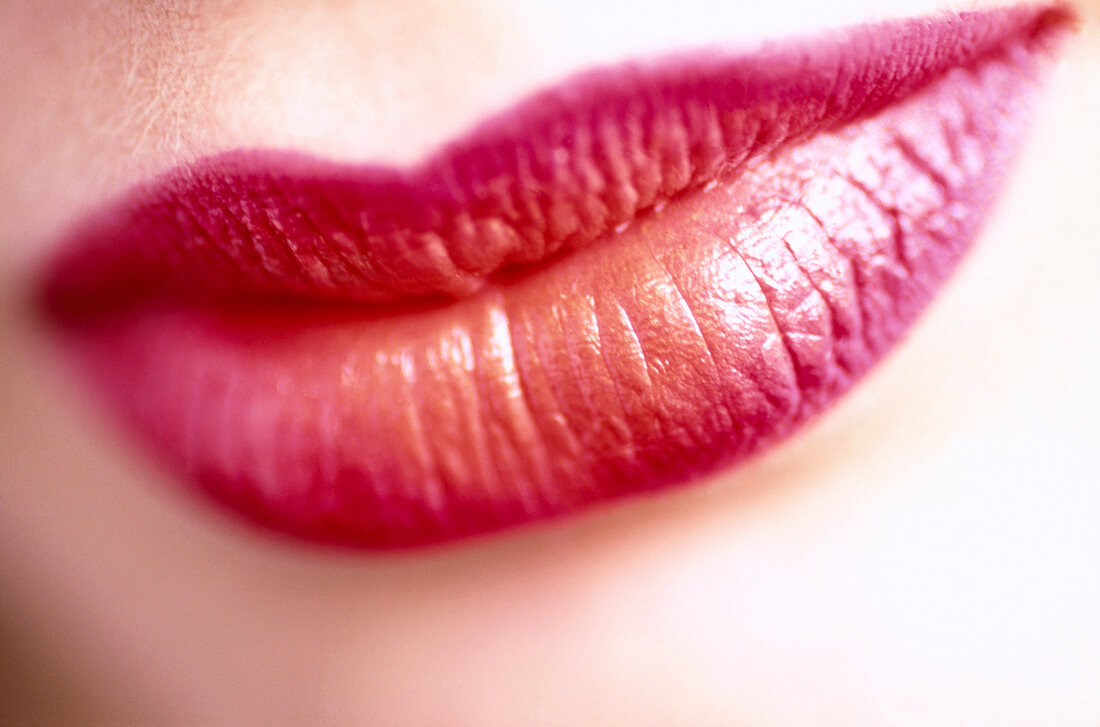 Close-up of woman's lips wearing red and orange colour lipstick