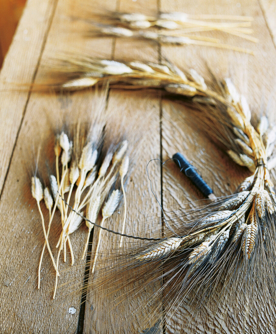 Close-up of craft materials for preparation of corn wreath on wooden table
