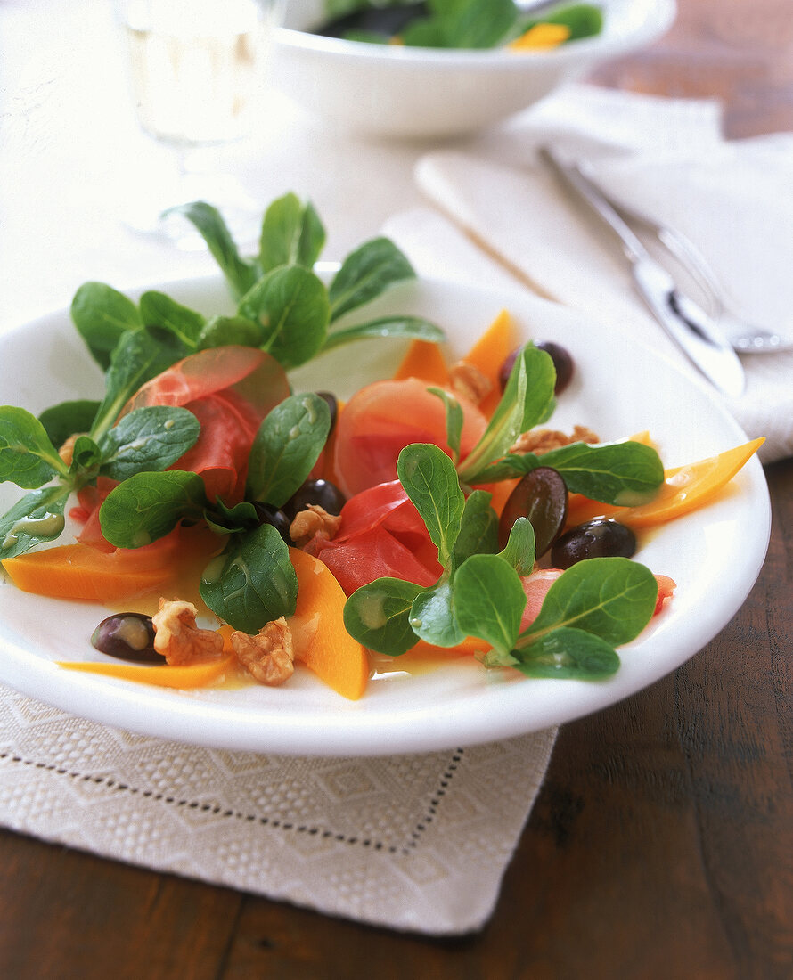 Bunter Salat aus Kürbis, Trauben, Feldsalat und Schinken