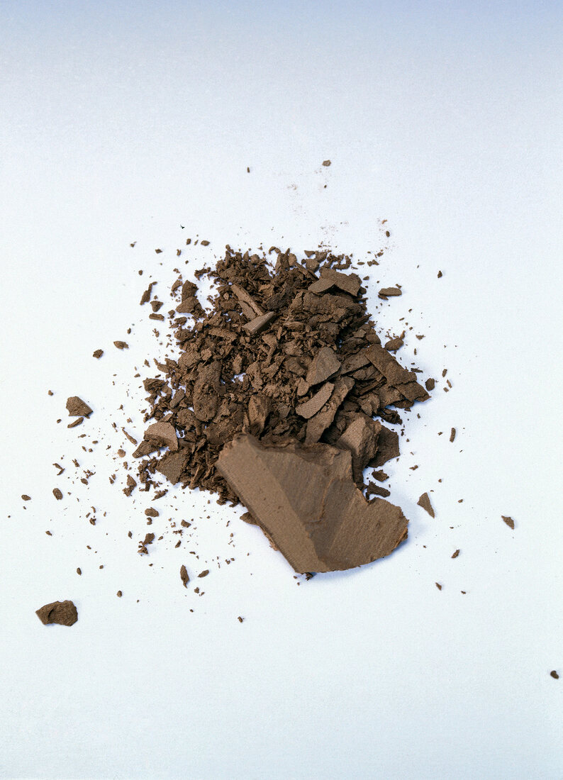 Brown powder blush crushed on white background