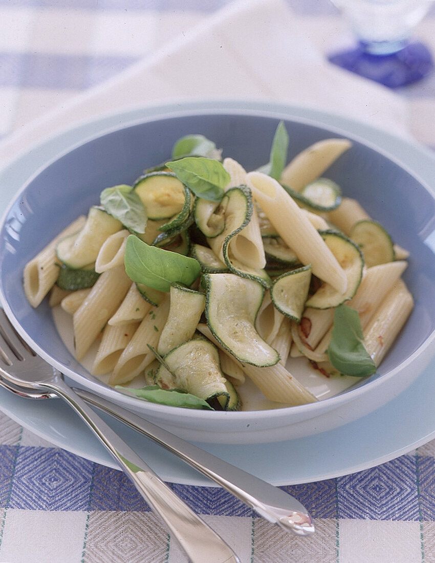 Penne mit Kräuter-Zucchini in hellblauem, tiefem Teller