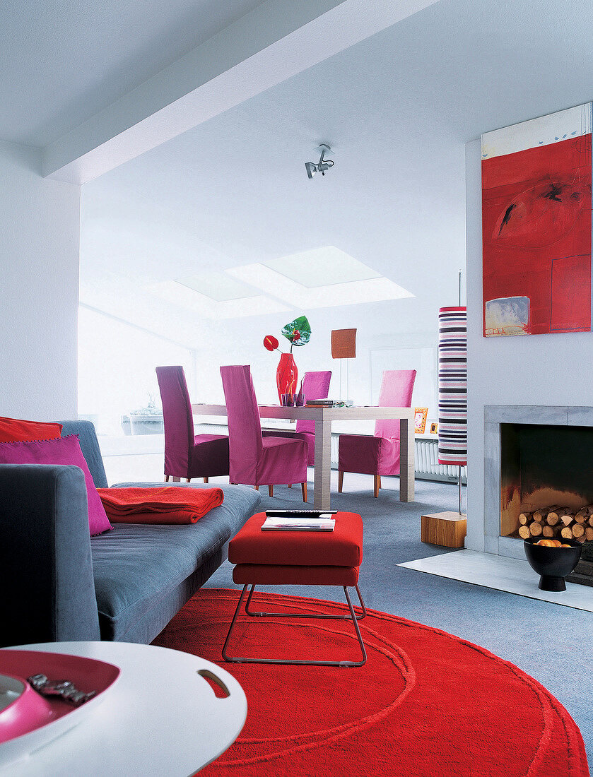 Dinning table, gray sofa and red stool in living room