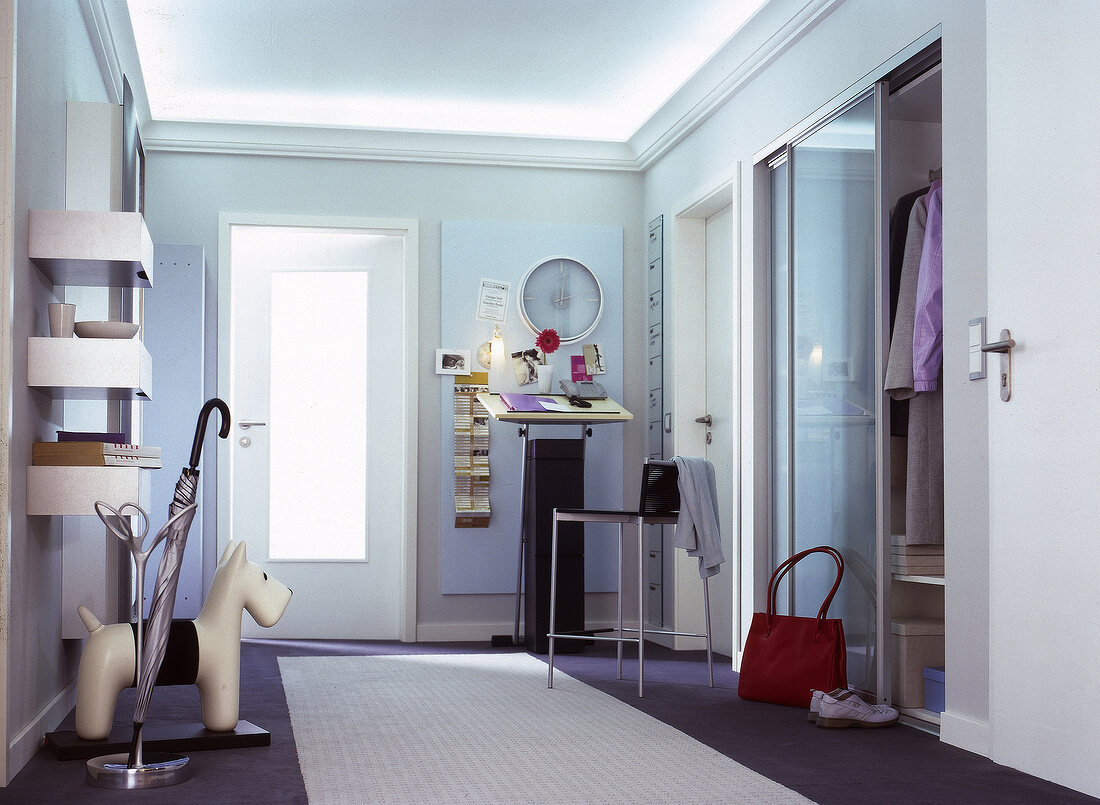 Flur im Office-Look mit Stehpult und eingebautem Garderobenschrank