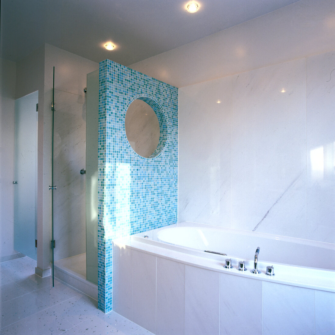 Turquoise mosaic partition between bath tub and shower