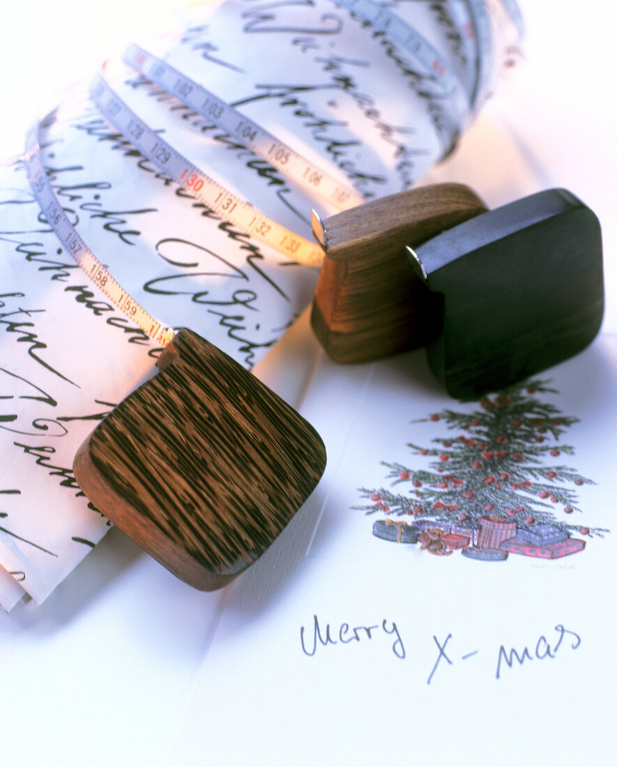 Mini-Maßbänder  in schöner Holzhülle liegen auf Weihnachtszeichnung