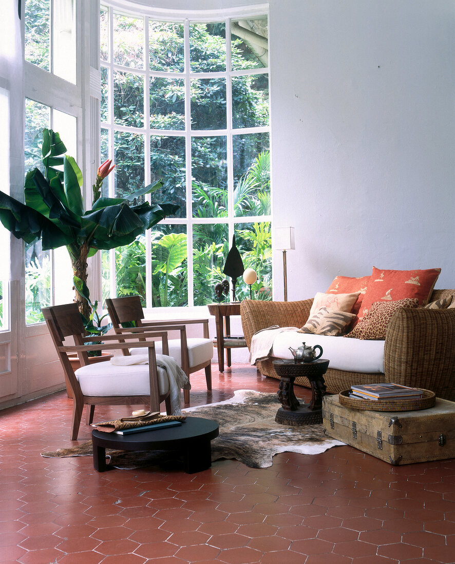 Raum mit großer Fensterfront im Kolonialstil mit Afrika-Accessoires