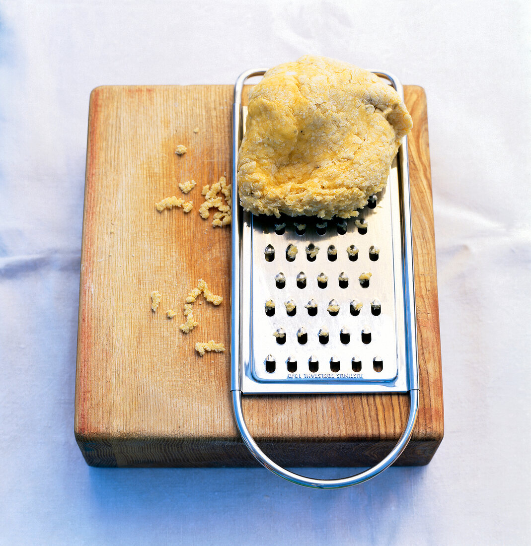 Dried pasta used for soup grated on wooden board