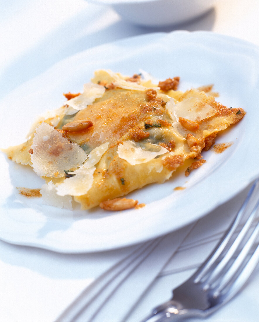 Close-up of spinach and goat cheese ravioli with egg on plate