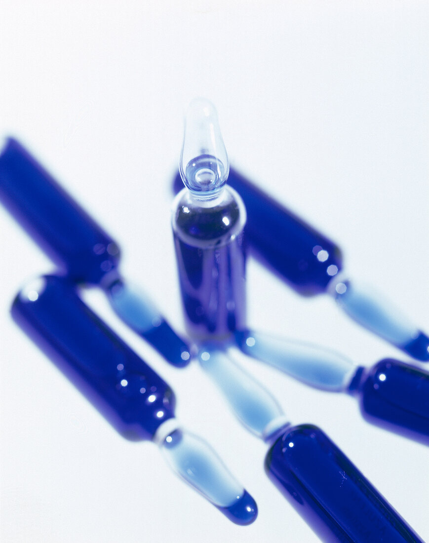 Close-up of ampoules filled with liquid anti-inflammatory agent on white background