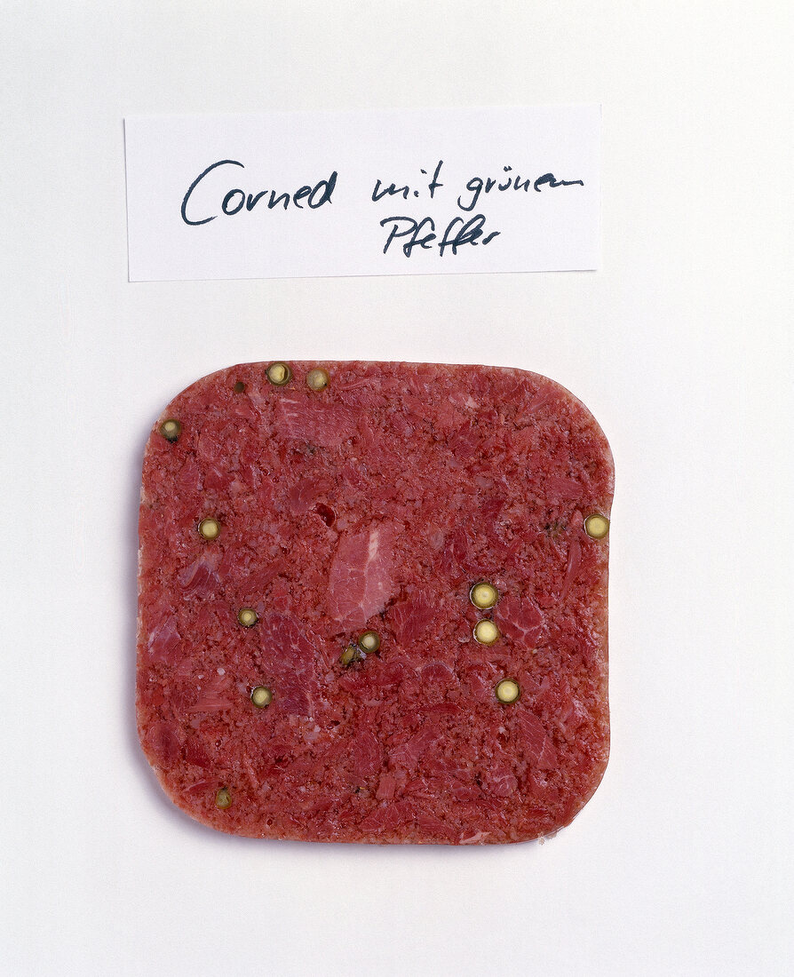 Slice of corned beef with green pepper on white background