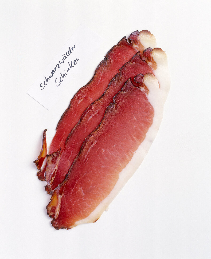 Slices of forest ham on white background