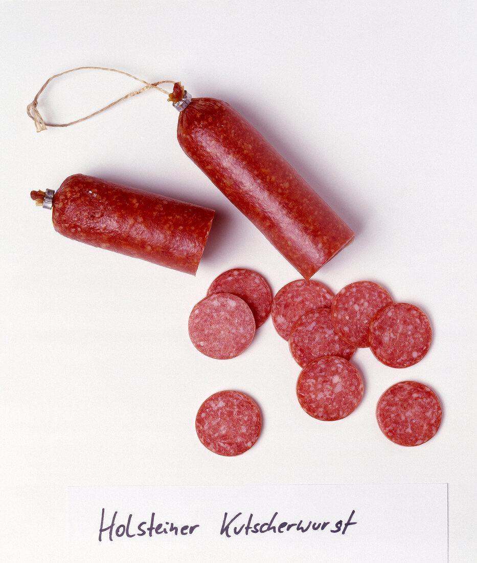 Slices of holsteiner sausages on white background