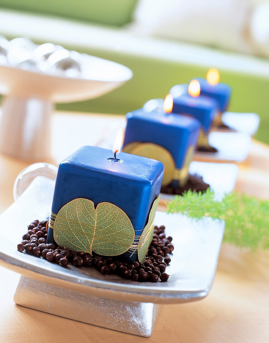 4 blaue Kerzen auf Silberschale verziert mit Blättern und Golddraht