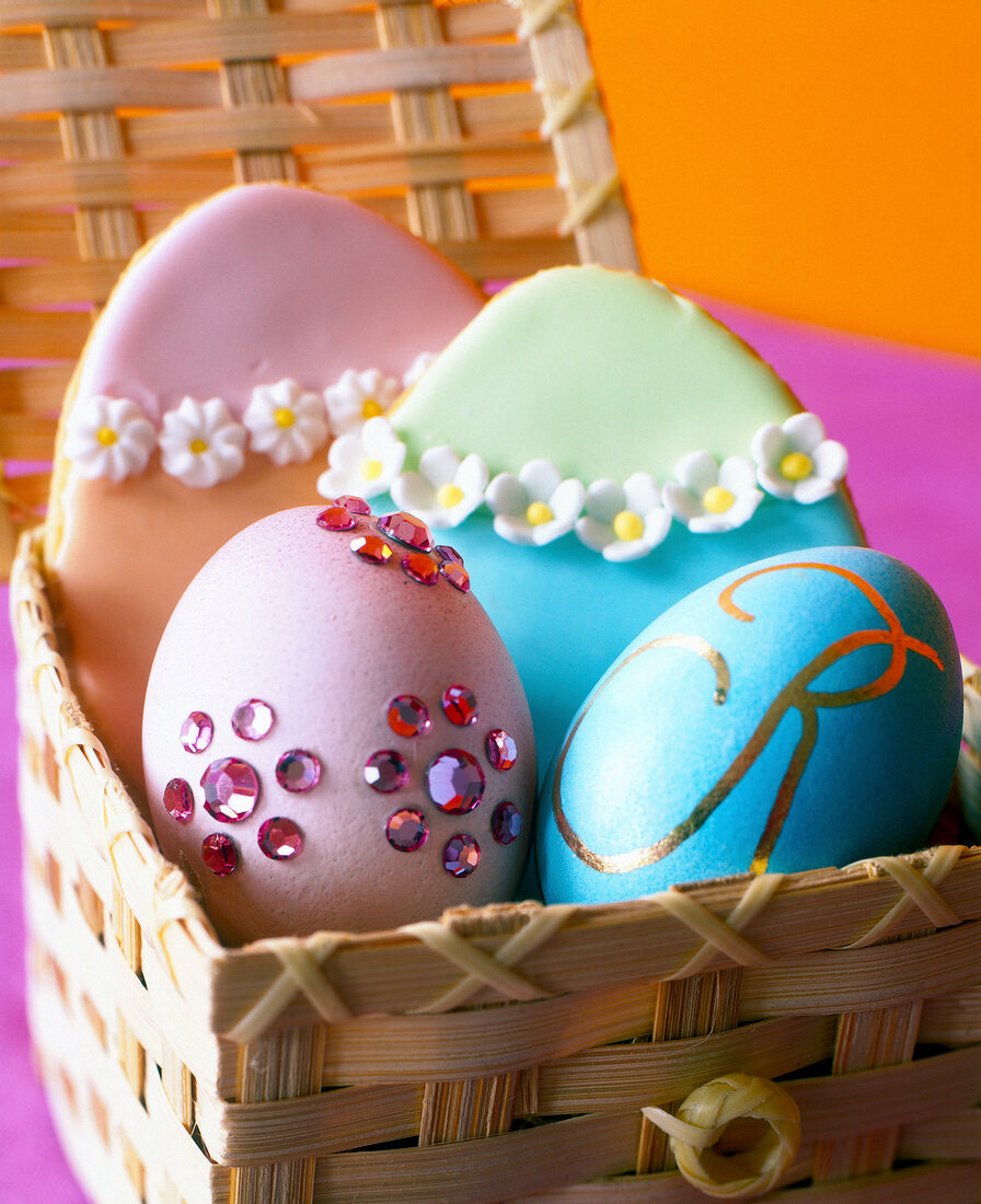 Close-up of two Easter eggs decorated with rhinestone and monogram in basket