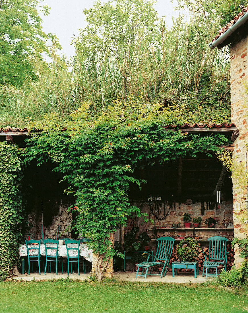 Essplatz unter bewachsener Laube in in einem alten Weingut, Italien