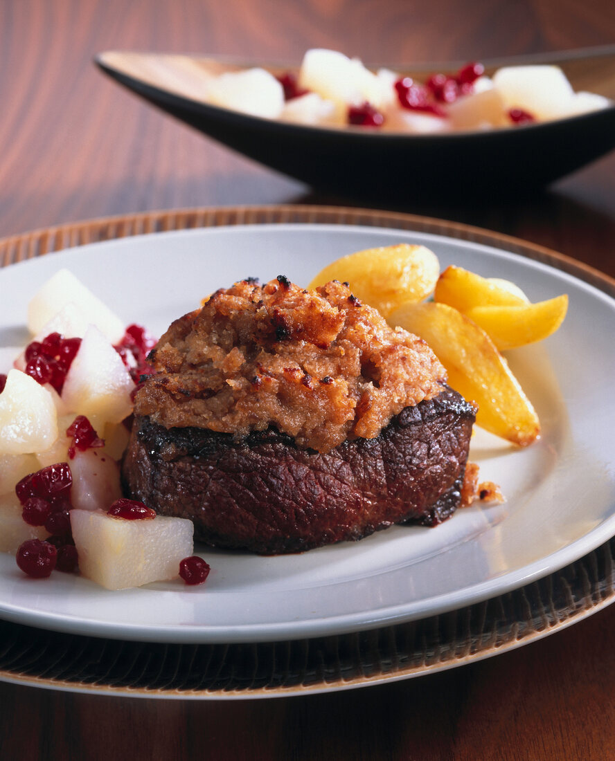 Venison medallion topped with chestnut crust served on plate