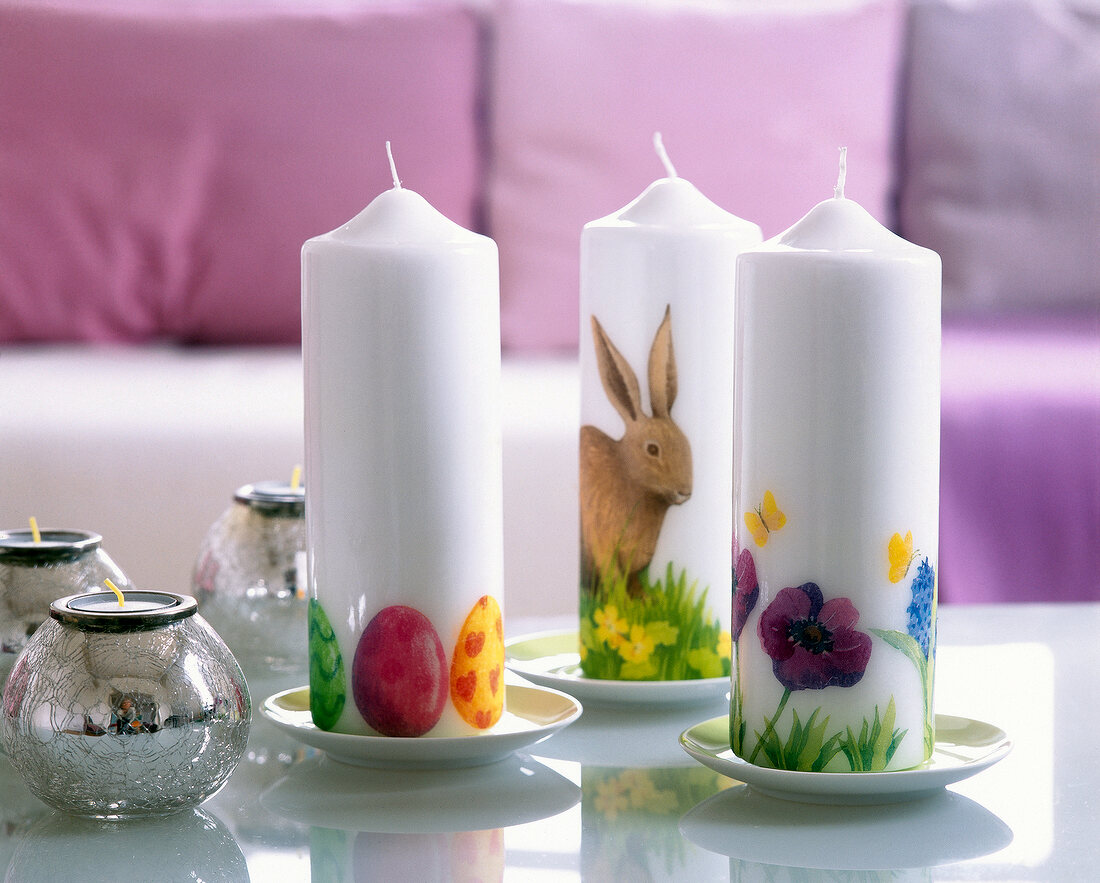 Three white candles decorated with Easter motives