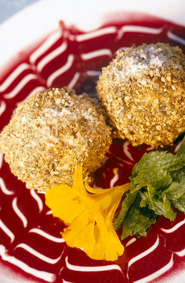 Close-up of chestnut balls with sour cherry sauce