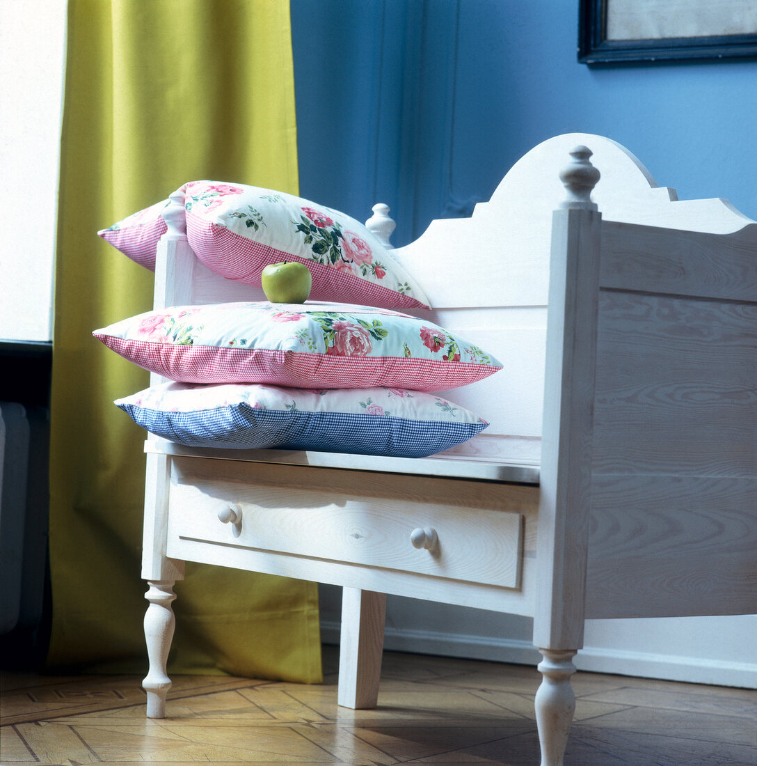 White table with two drawers and three pillows