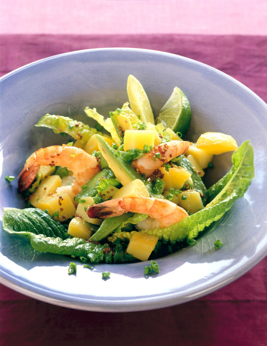 Potato salad with shrimp, avocado, lime, mustard seeds and romaine lettuce on plate