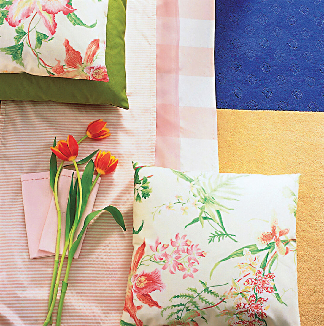 Ensemble in Sommerfarben: zarte Blumenkissen auf rosa Stoff, Tulpen