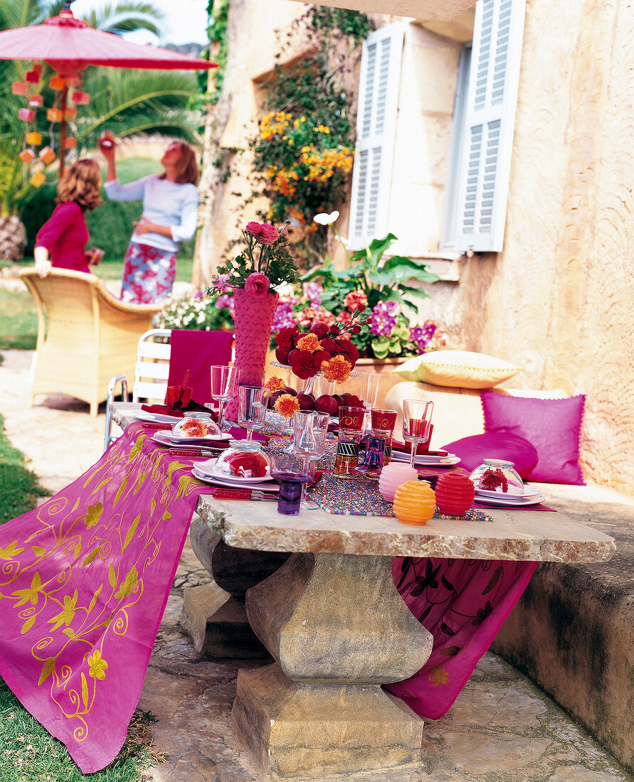 Sommerlich gedeckter Steintisch mit Organzadecke, Glasperlenset, rot