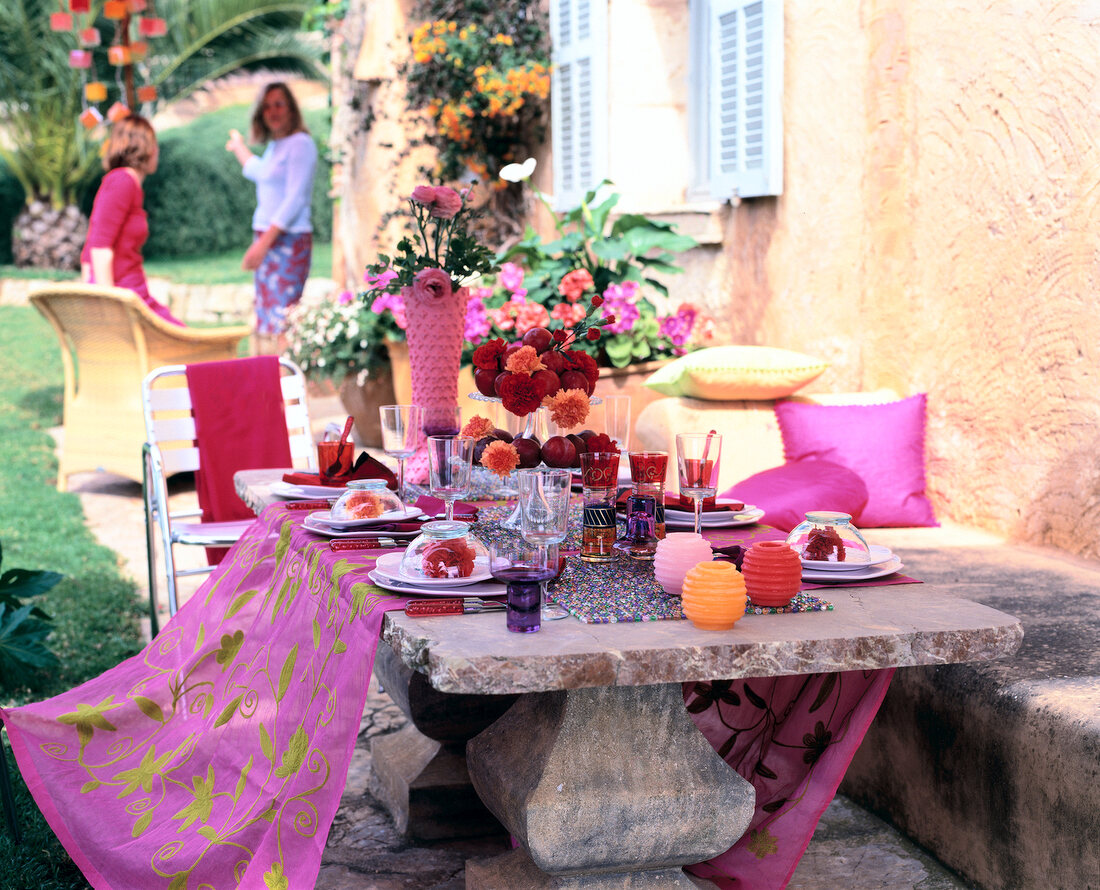 Sommerlich gedeckter Steintisch mit Organzadecke, Glasperlenset, rot