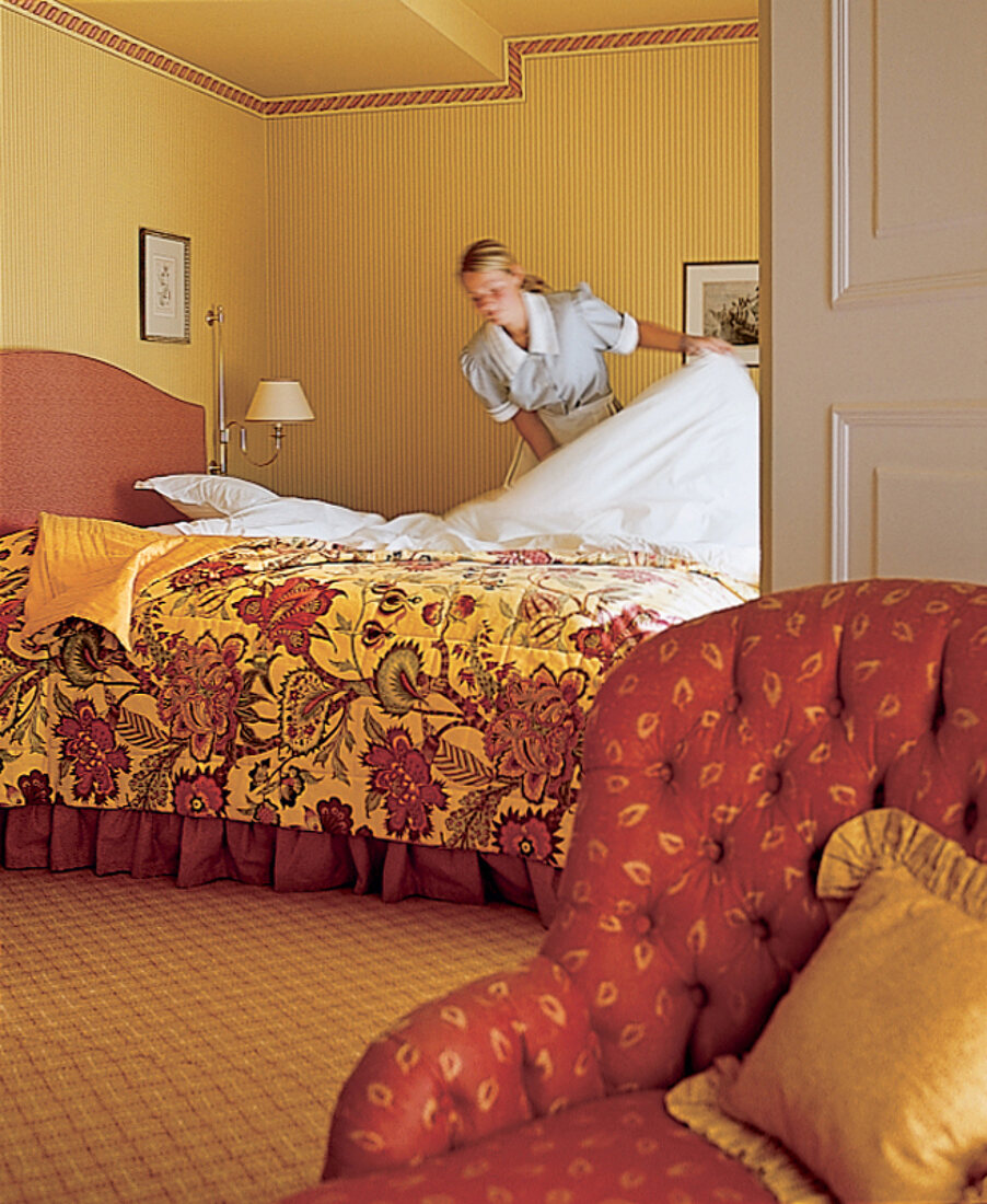 Zimmermädchen schüttelt Bett des Hotel  Stadt Hamburg / Sylt auf