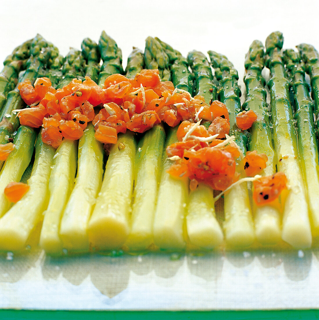 Row of green asparagus garnished with char tartare