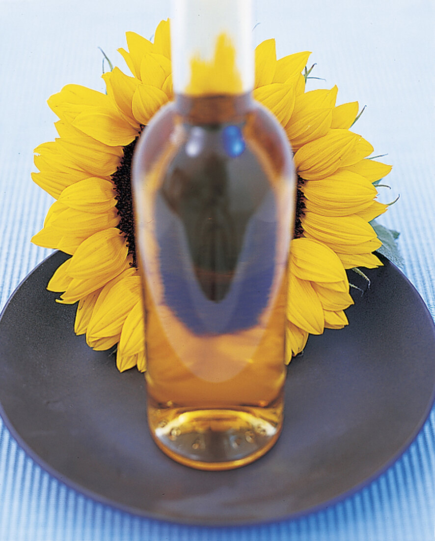Flasche Sonnenblumenoel vor einer Sonnenblume
