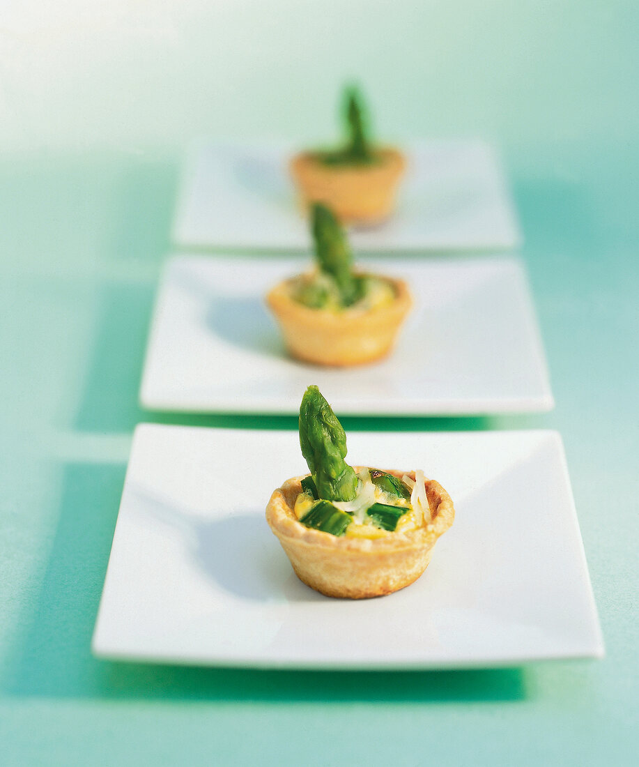 Tarts with asparagus on square plates