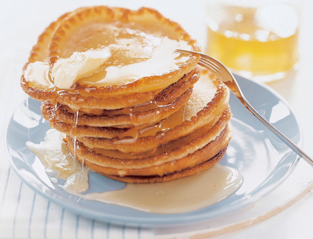 Stack of pancakes with maple syrup on plate, USA