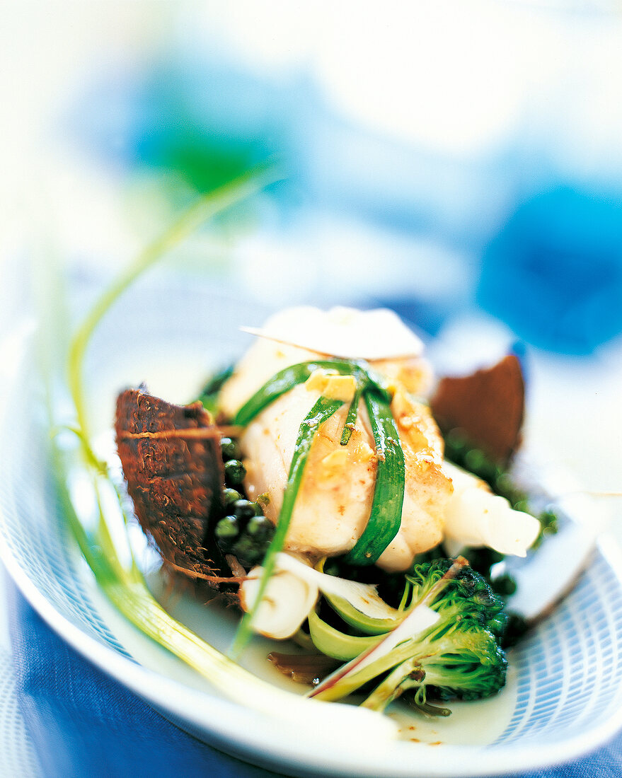 Close-up of cod with broccoli and peanut sauce on plate