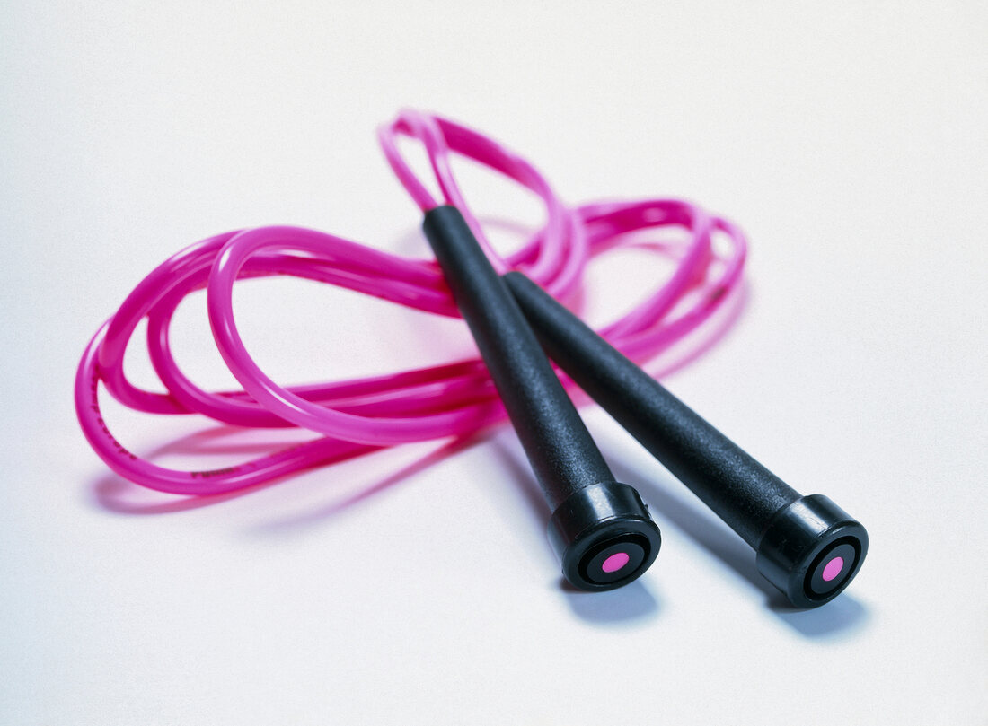 Close-up of pink skipping rope on white background