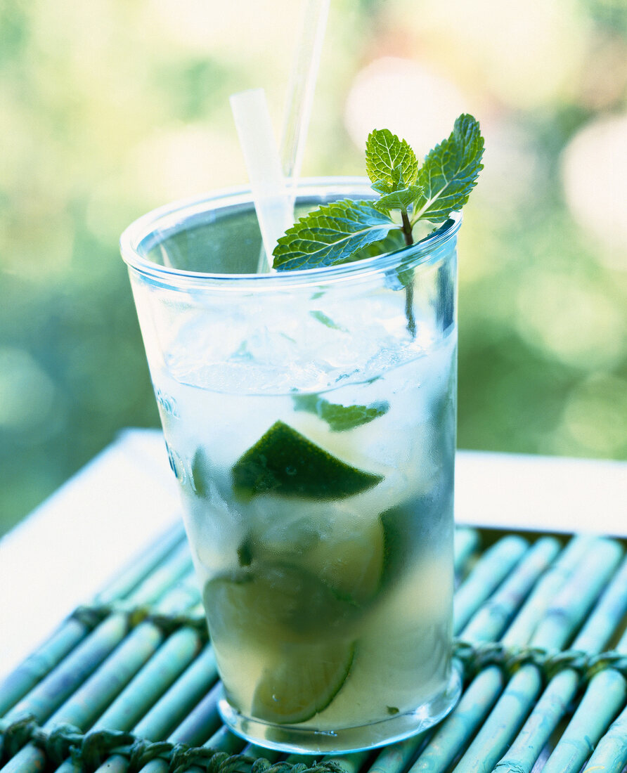 Glass of mojito cocktail with lime, rum and sugar garnished with mint leaves