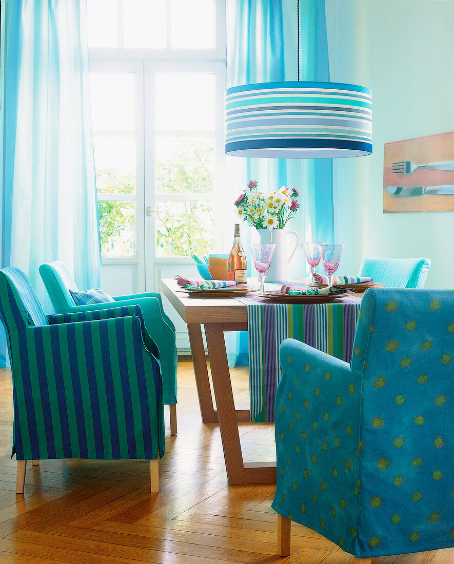 Four blue armchairs and dining table in dining room