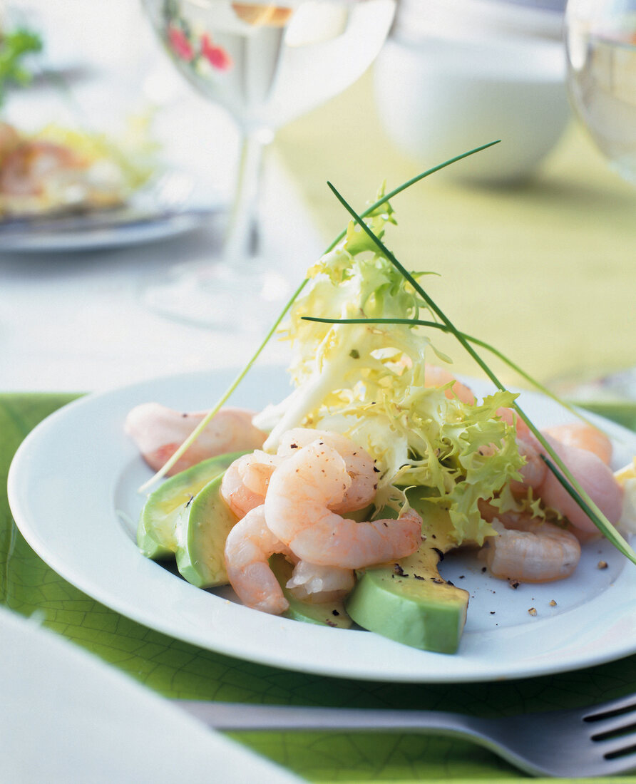 Shrimp cocktail with frisee and avocado on plate