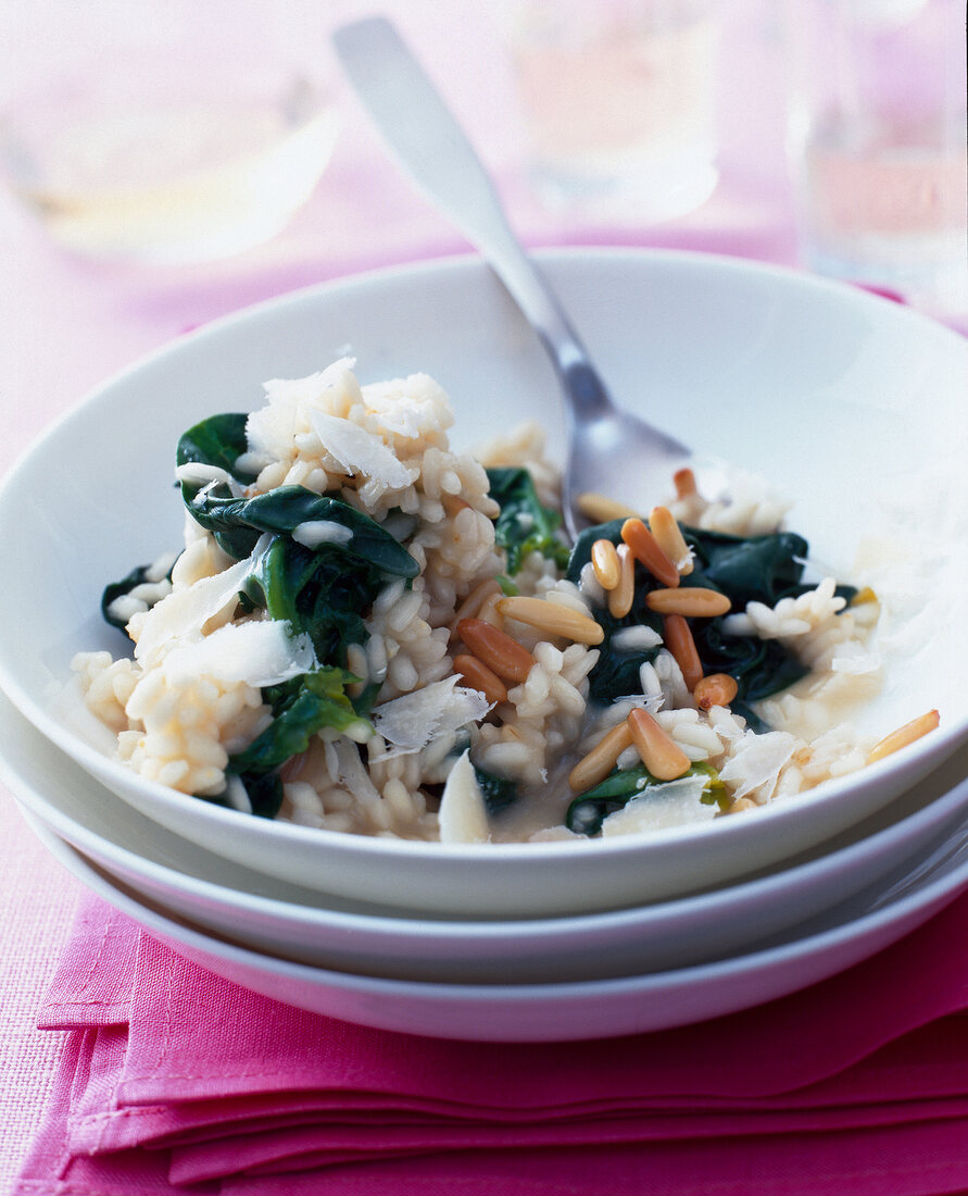 Spinach risotto with pine nuts in bowl