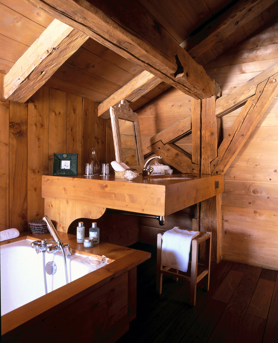 View of rustic bathroom with wooden ceiling and walls