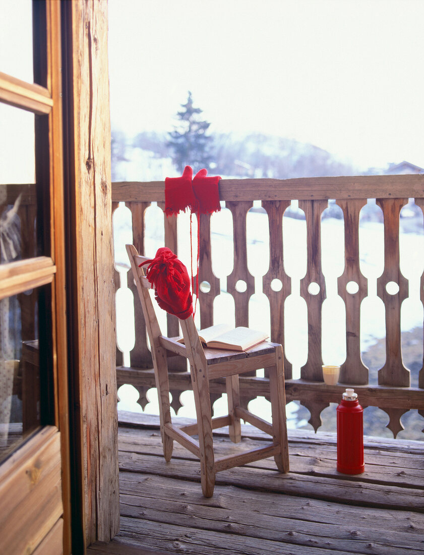 View of rustic balcony with chair and book