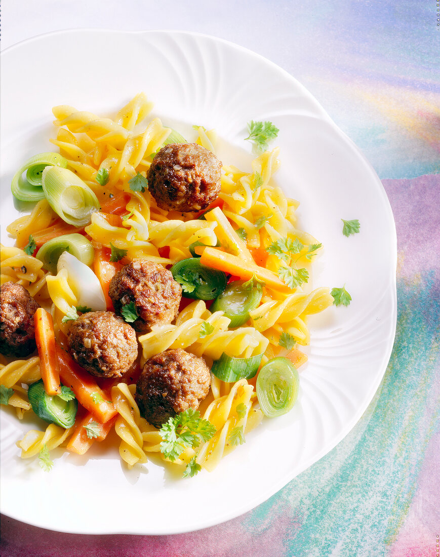 Close-up of vegetables fusilli with meatballs on plate