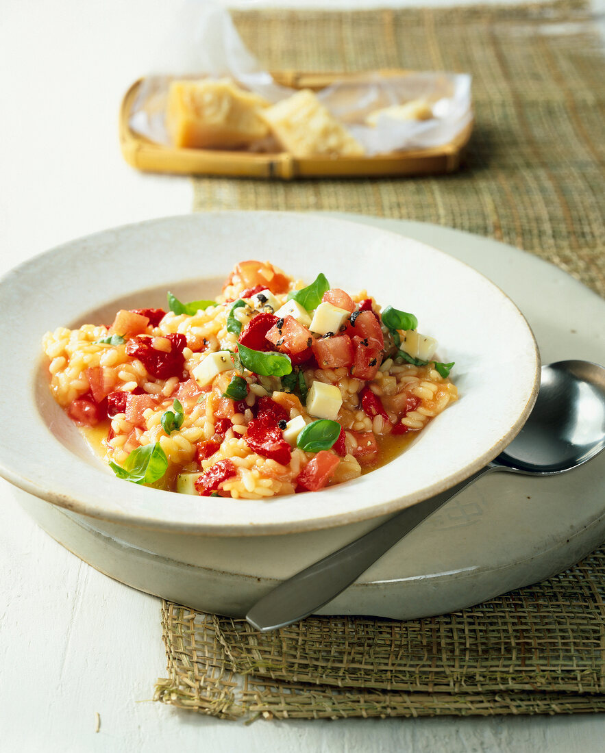 Risotto with tomato, basil, mozzarella and parmesan on plate