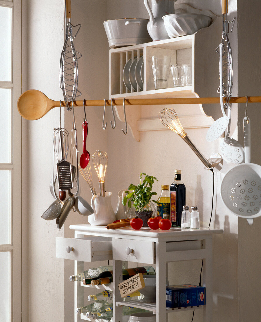 Kochutensilien hängen am langen Kochlöffel in weißer Küche