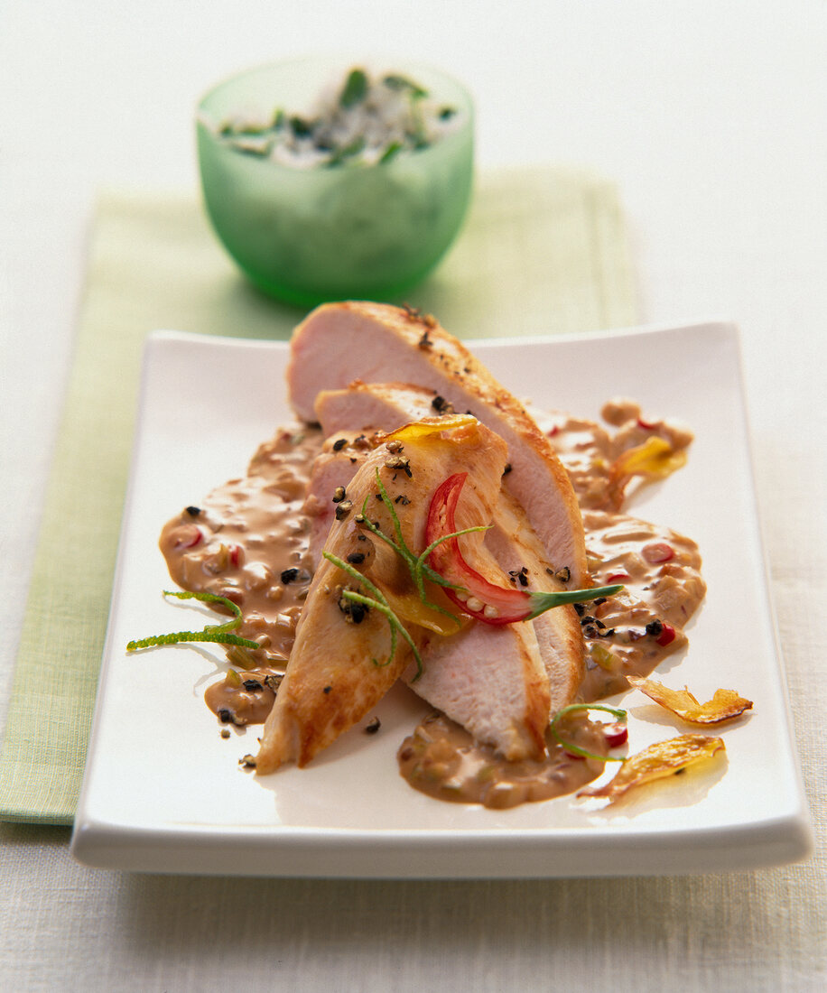 Chicken with peanut sauce on white plate