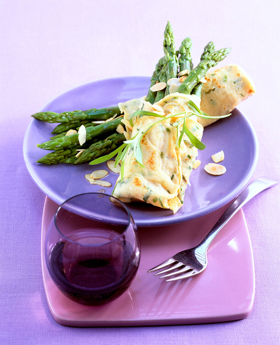 Tarragon crepes with asparagus on purple plate