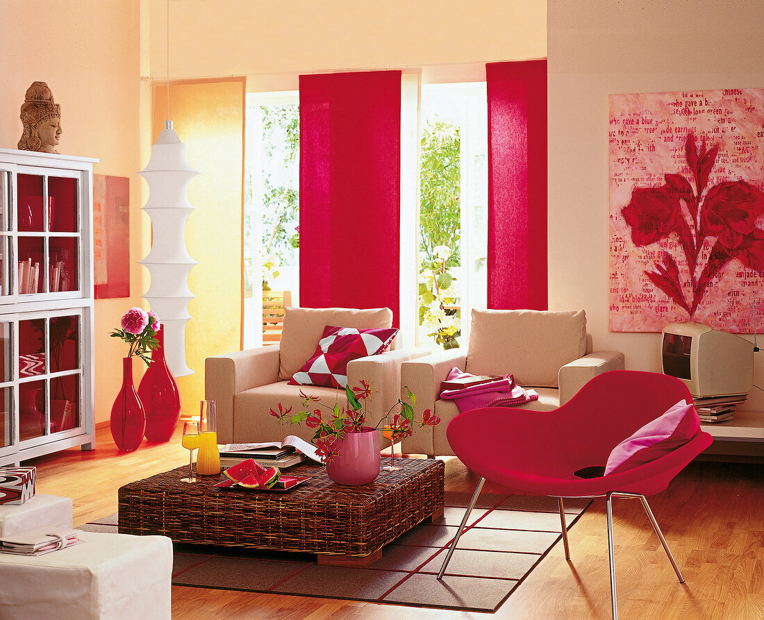 View of living room with armchair, coffee table, shell chair and picture curtain