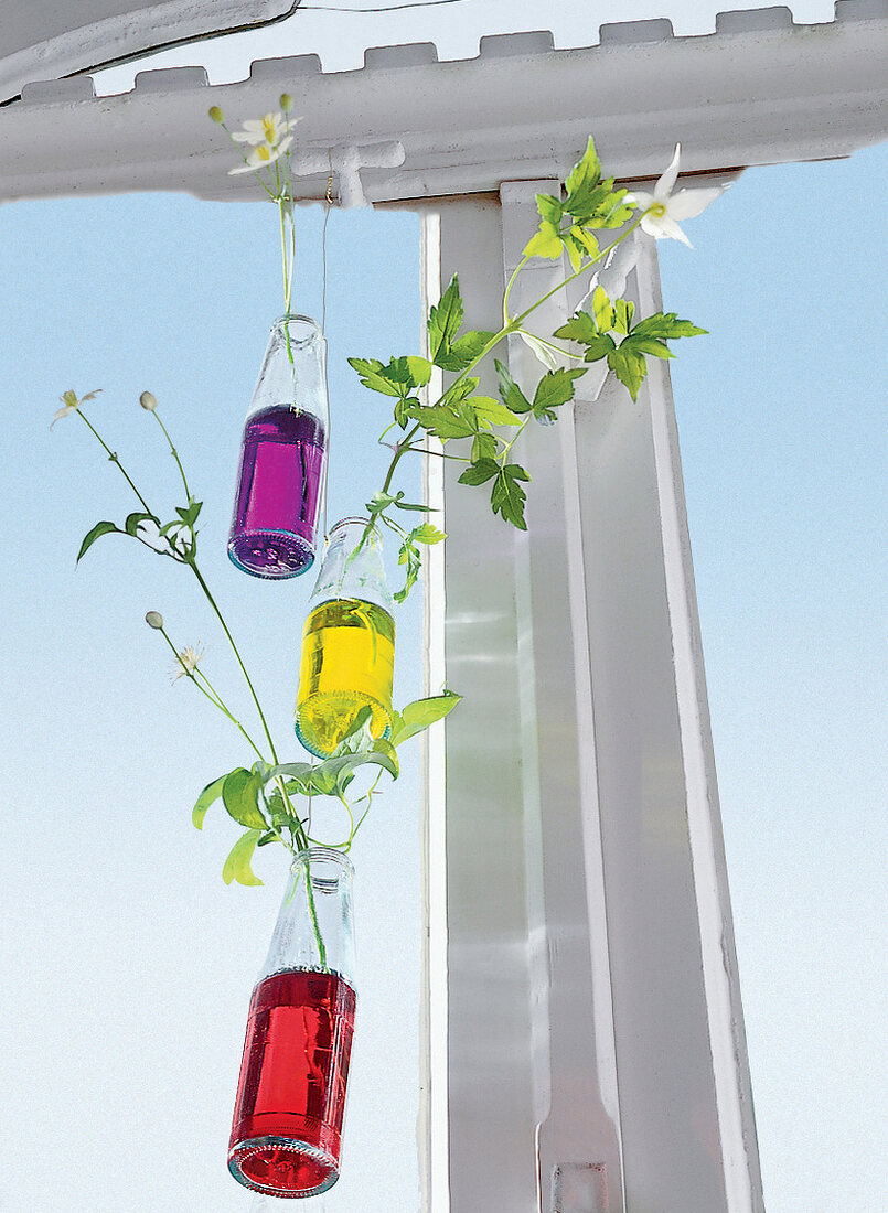 Flaschen hängen in unterschiedlicher Höhe an Drähten, gefüllt mit Wasser