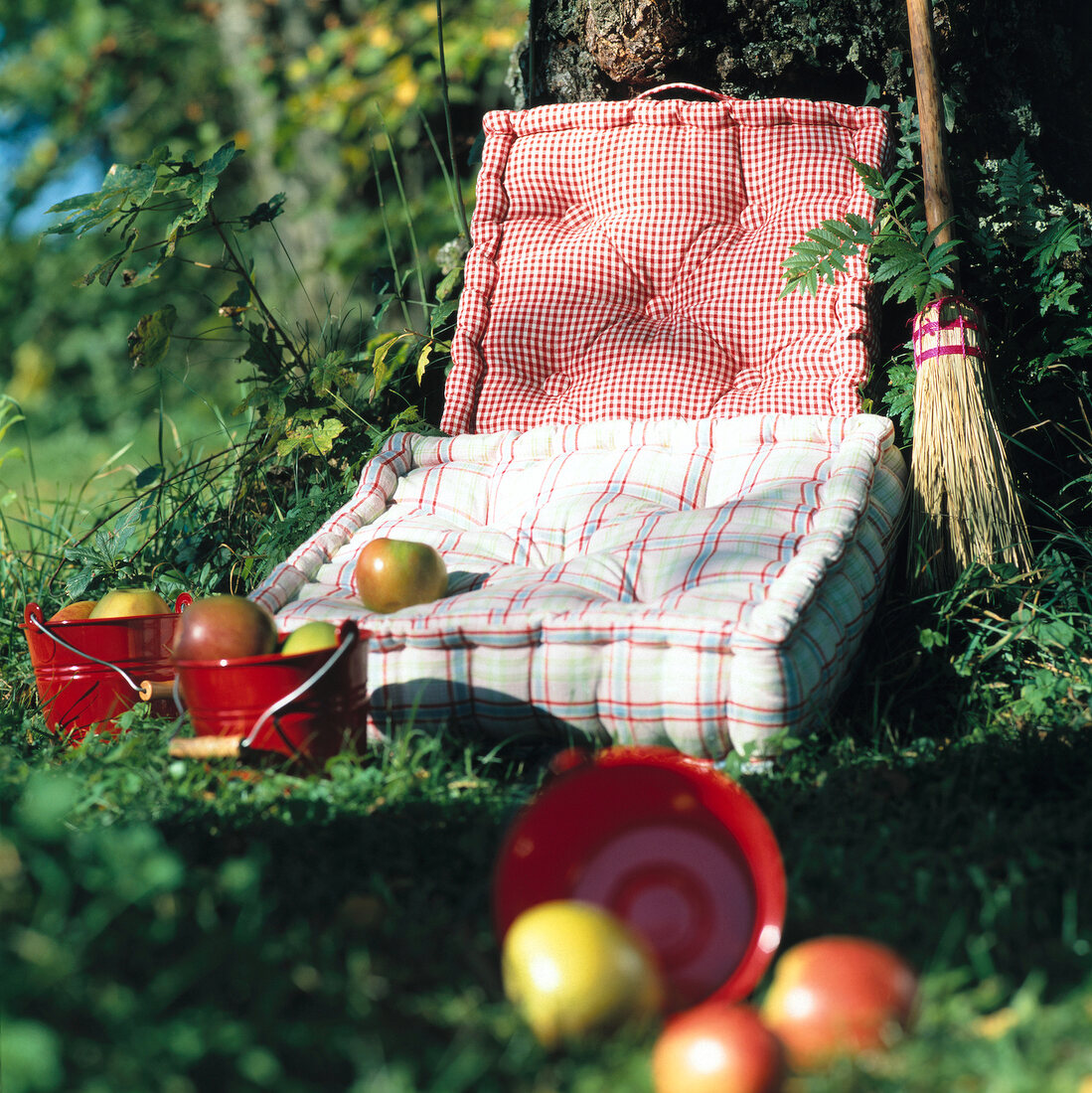 Mattresses pillows with fruits in small bucket on grass