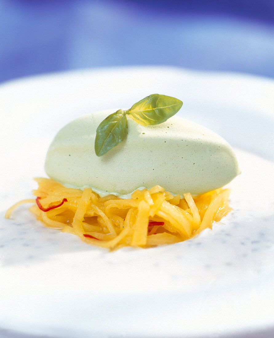 Close-up of green tea ice cream on mango-chilli spaghetti with lemongrass